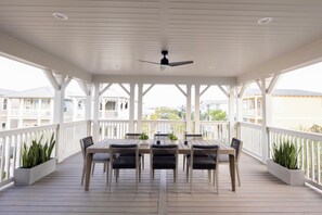 A covered outdoor patio with a table and chairs, surrounded by white railings and potted plants. - NEW! Spacious Home, 3rd Fl Patio and Bar w/ Costal View! (Panama City)