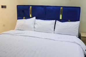 A bed with a blue headboard and white bedding.