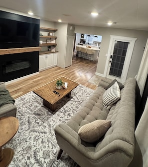 A modern living room with a sofa, coffee table, and a TV. - Villa M, a cozy home with firepit, few blocks away from town square (Humboldt)