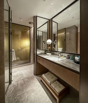 Een moderne badkamer met een grote spiegel, een wastafel en een douchehoek.