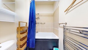 A small bathroom with a shower, a wooden shelf, and a towel rack. - Stunning Studio Flat, Charring Cross Prime Location of London (London)