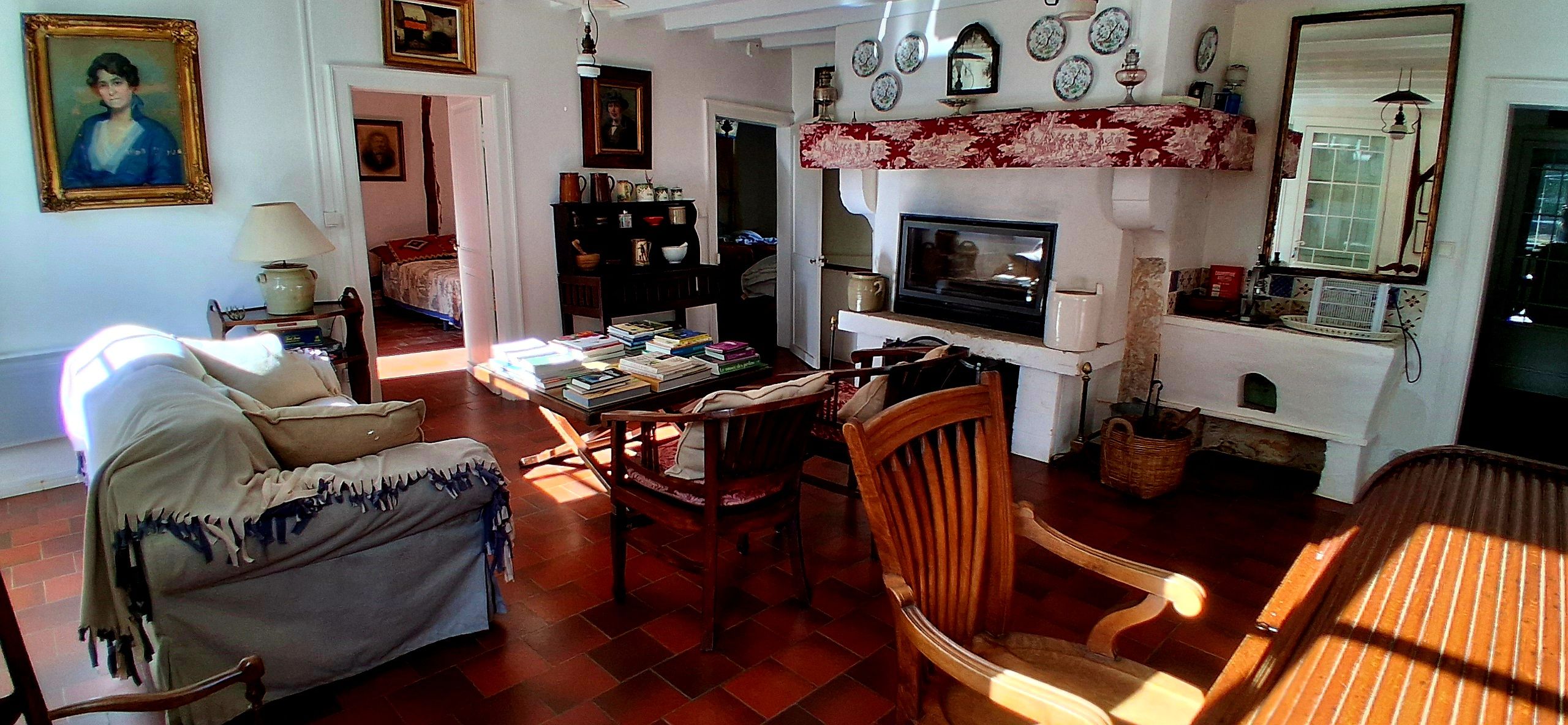 Una sala de estar acogedora con chimenea, una estantería y un comedor.