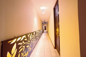 A corridor with a patterned railing, a door on the right, and a light fixture on the ceiling. - Hotel Niut-Ja (Oaxaca)