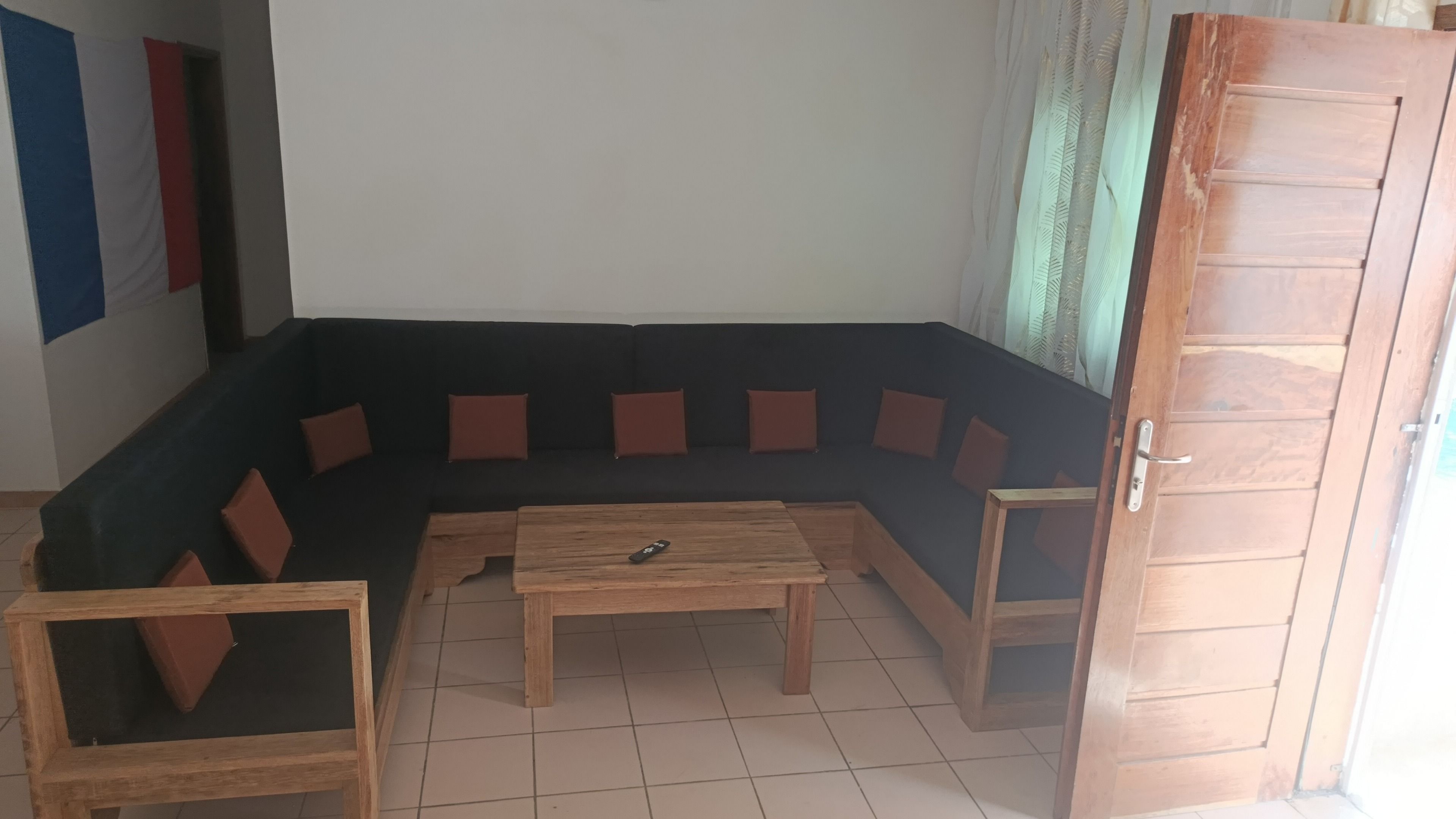 Een zithoek met een donkergrijze modulaire bank, een houten salontafel en een klein houten bijzettafeltje.
