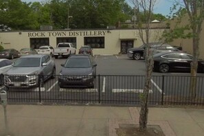 A parking lot with several cars and a building labeled 'Rock Town Distillery.' - Solost SOMA Little Rock (Little Rock)