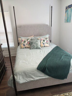 A bed with a headboard, multiple pillows, and a blanket. - Spacious 4-bedroom house in beautiful Kissimmee (Kissimmee)