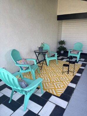 A set of turquoise chairs and a small table with a potted plant, arranged on a patterned rug. - Spacious 4-bedroom house in beautiful Kissimmee (Kissimmee)