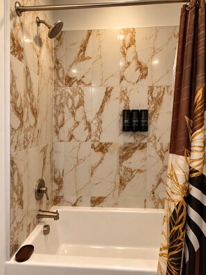 A bathroom with a bathtub, a shower, and a toilet. - The Luxe Noir near Downtown Atlanta (Atlanta)