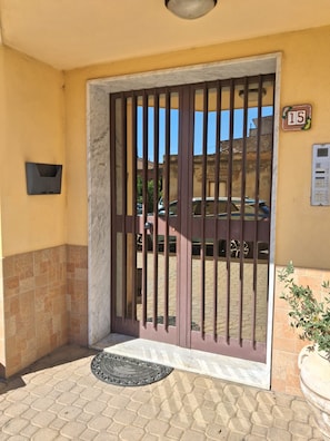 A gated entrance with a number sign, a mailbox, and a potted plant. - Aster Rhegion Apartment Your Vacation Home Reggio Calabria,Beach, City Mountains (Reggio Calabria)