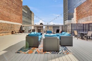An outdoor patio with wicker furniture and a patterned rug. - PremiumStays: 2 bd loft w/balcony : Playhouse sq : Theater : Arena : Parking (Cleveland)