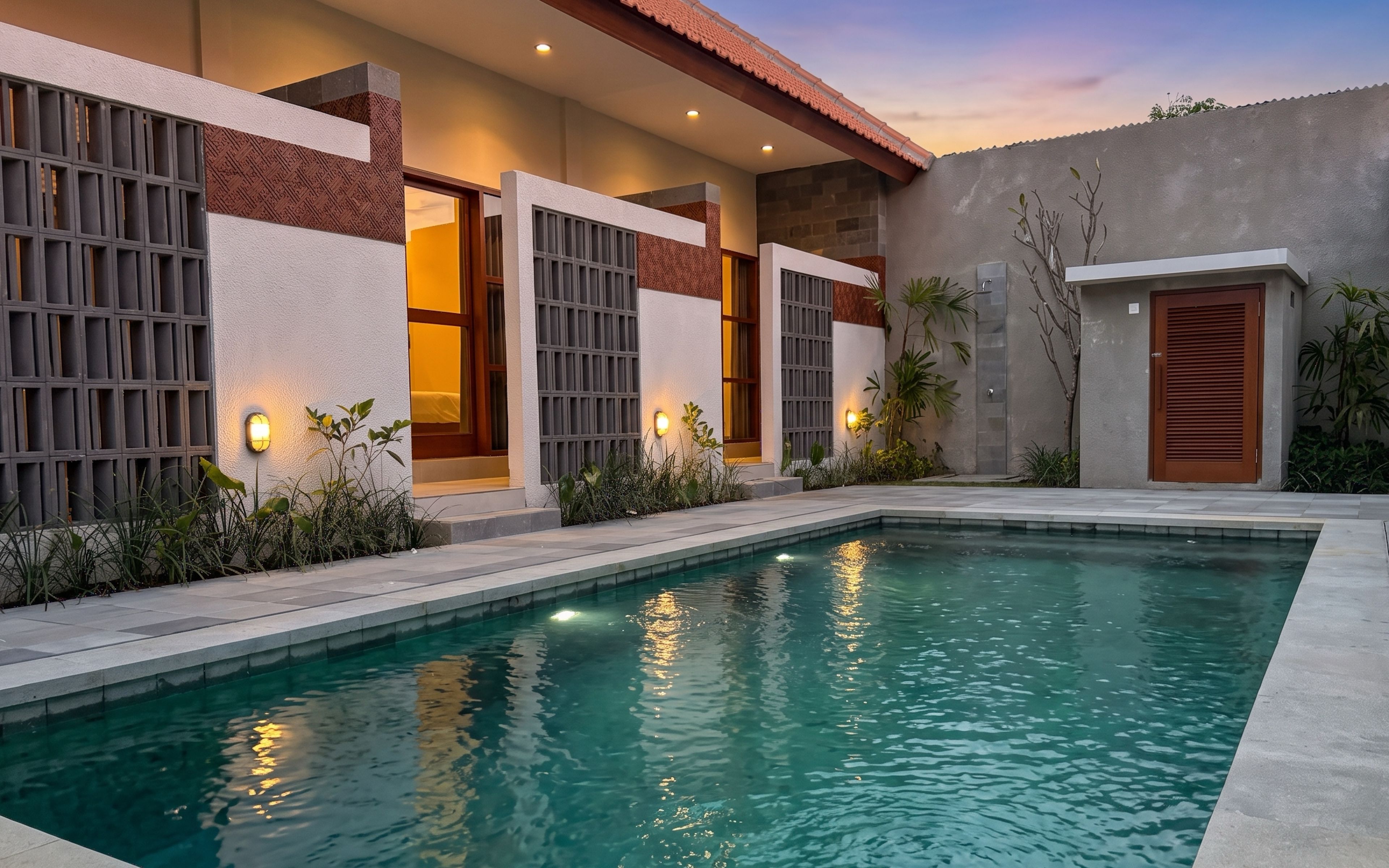 A swimming pool with a modern house in the background.