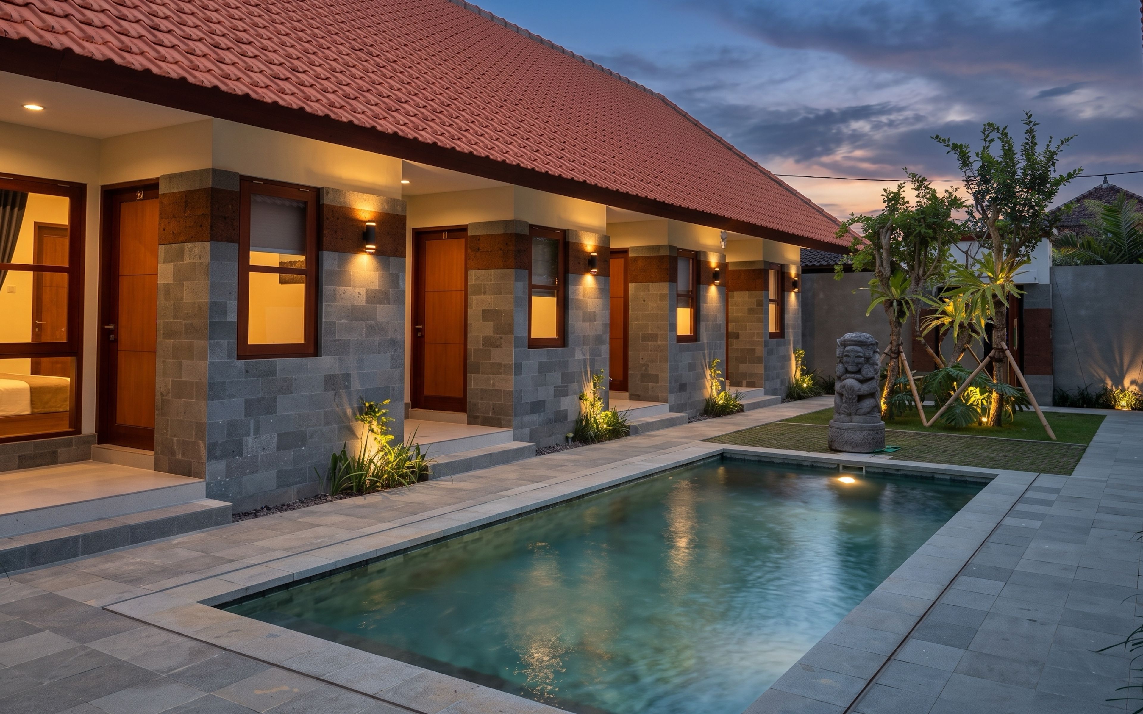 A modern house with a swimming pool, stone walls, and a red-tiled roof.
