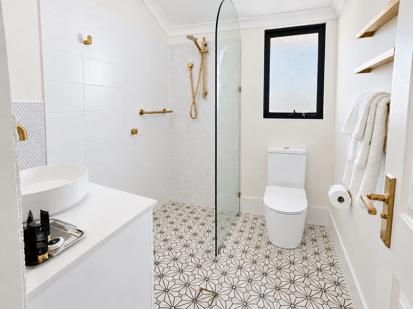 A bathroom with a white sink, toilet, and shower area.