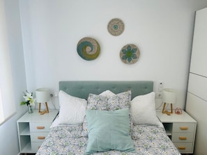 A bedroom with a bed, two bedside tables, and wall decor. - DELUXE FAMILIAR  (Albacete)