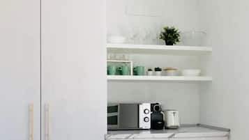 Una cocina moderna con armarios blancos, una mesa de comedor blanca y una decoración de cactus.