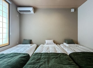 A room with two beds, a window, and an air conditioning unit. - HANASTAY MUKAI MIGIWA & SUZU (Osaka)