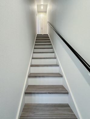 Un escalier muni d’une rampe et d’un luminaire au sommet.
