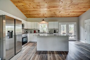 A modern kitchen with a central island, stainless steel appliances, and a wooden ceiling. - Peaceful New 3BR East Tennessee Retreat- Fire Pit - Deck- Garage (Sweetwater)