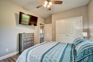 A bedroom with a bed, dresser, ceiling fan, TV, and white doors. - Peaceful New 3BR East Tennessee Retreat- Fire Pit - Deck- Garage (Sweetwater)