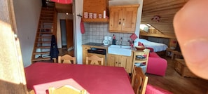 A compact room with a kitchenette, a dining area, and a bed. - Duplex apartment at the base of the slopes, sleeps 6, 50 m²—Les Saisies—Les Contamines-Montjoie (Hauteluce)