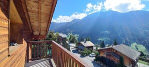 A wooden cabin with a balcony overlooking a valley and mountains. - Duplex apartment at the base of the slopes, sleeps 6, 50 m²—Les Saisies—Les Contamines-Montjoie (Hauteluce)