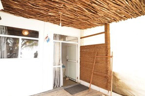 A room with a thatched roof, a door, a window, and a mat at the entrance. - Mini Beach Villa - Hikkaduwa (Hikkaduwa)