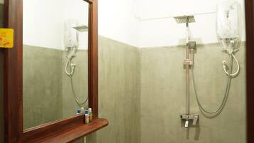 A bathroom with a sink, mirror, shower, and a sign indicating a shower room.