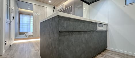 A modern kitchen with a built-in island, recessed ceiling lights, and a large window.