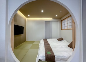 A circular room with a bed, a television on the wall, and a sliding door. - HANASTAY KIWAMI (Osaka)