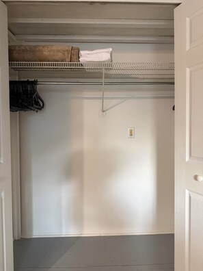 A room with a white ceiling, a metal shelf, a power outlet, and a door. - Cozy Private Studio, 20 Minutes from Disney (Clermont)