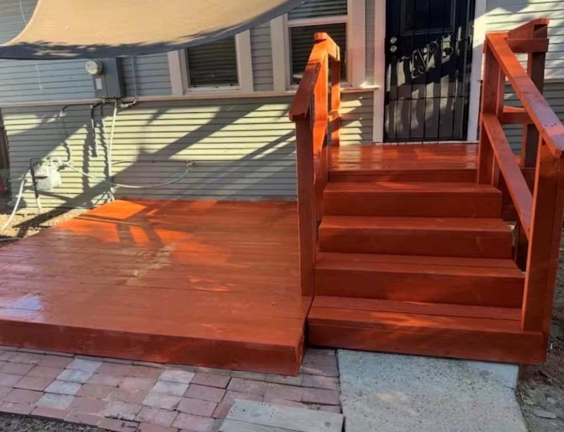 Una escalera de madera que lleva a un espacio exterior cubierto con base de ladrillo.