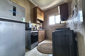 A kitchen with a refrigerator, stove, cabinets, and a window. - Soul OF Pyramids Golf Epic view (Giza Governorate)