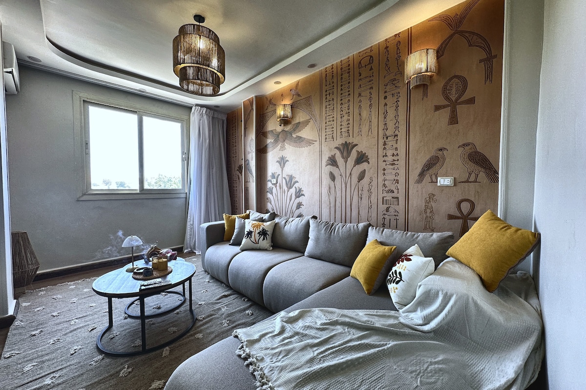 A modern living room with a sectional sofa, a round coffee table, and decorative pillows.