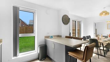 Una cocina moderna con comedor, ventanas amplias y vistas al exterior.