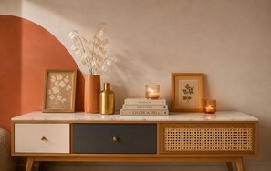 A marble-top console with decorative items, including framed artwork, a vase with dried flowers, and books. - Monaco Luxury Apartment • Terrace • Parking • Sleeps 5. View of Monaco (Beausoleil)