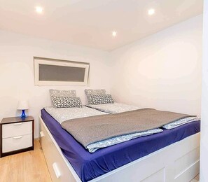 A bedroom with a bed, bedside tables, and a nightstand. - Fantastic 2-bedroom apartment in the heart of vibrant Budapest. (Budapest)
