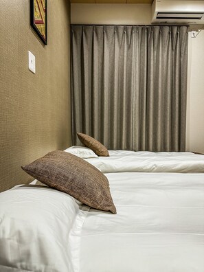 A hotel room with two beds, a wall-mounted air conditioner, and a curtain. - HANASTAY TSUMUGI (Osaka)