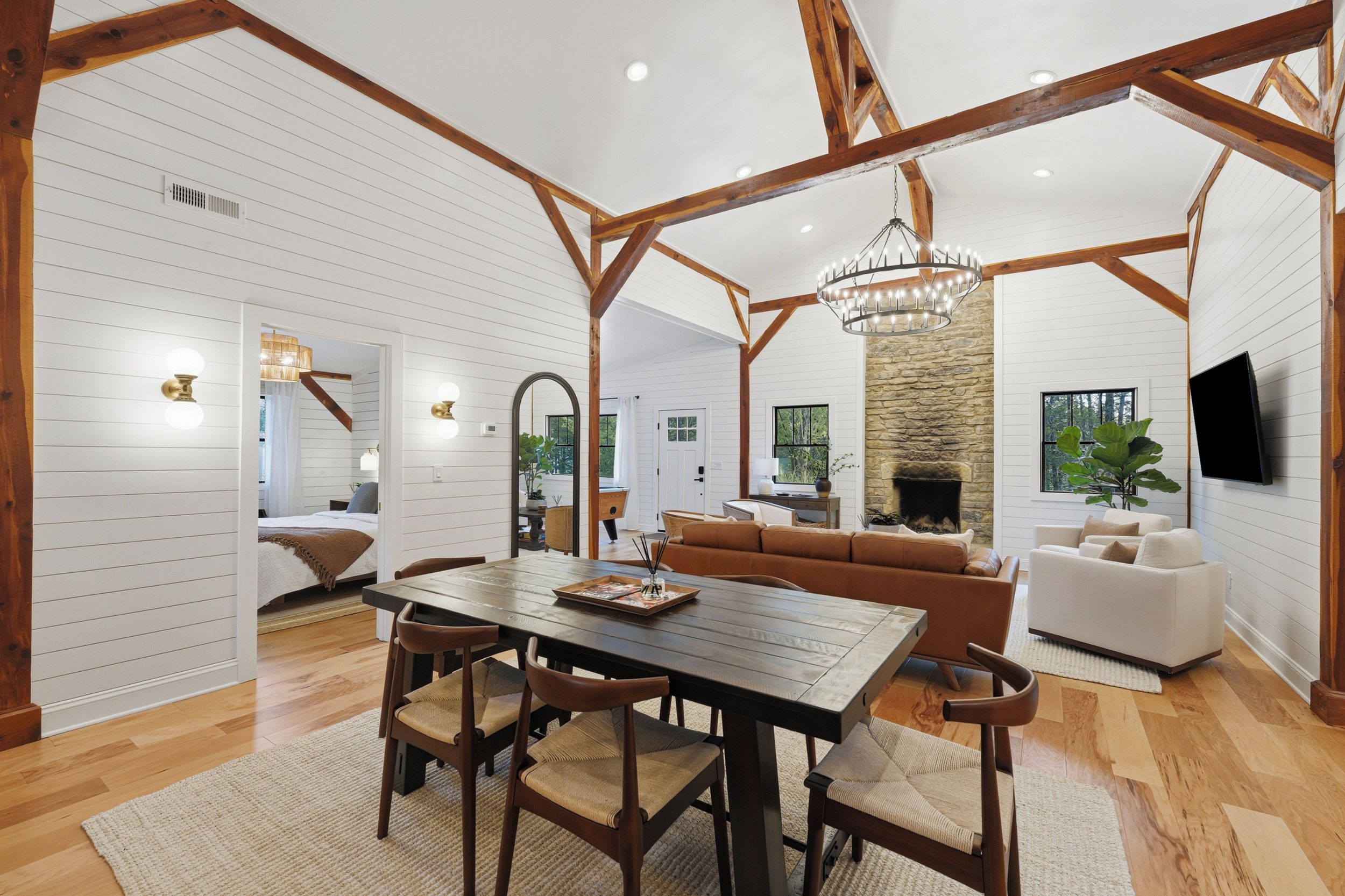 A spacious living area with a dining table, sofas, and a stone fireplace.