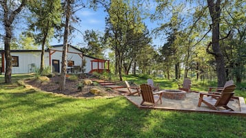 Une cabane dotée d’une terrasse, entourée d’une forêt.