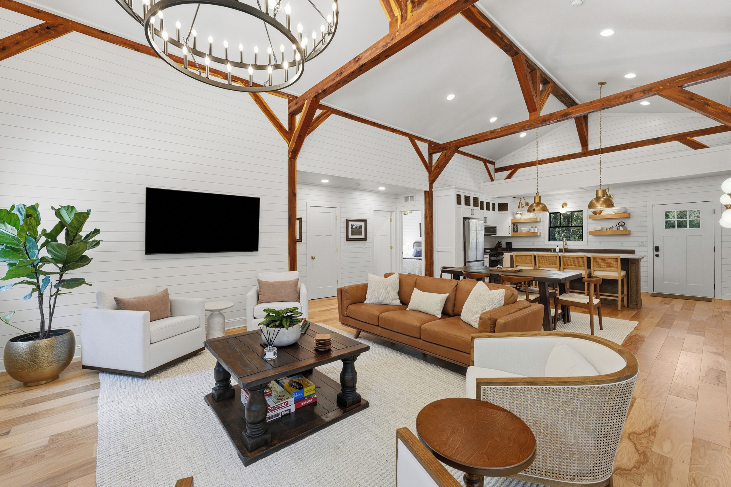 Una sala de estar amplia con chimenea, un comedor y una cocina con vigas de madera.