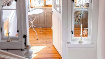 Een trap die leidt naar een kamer met een houten vloer en een witte balustrade.