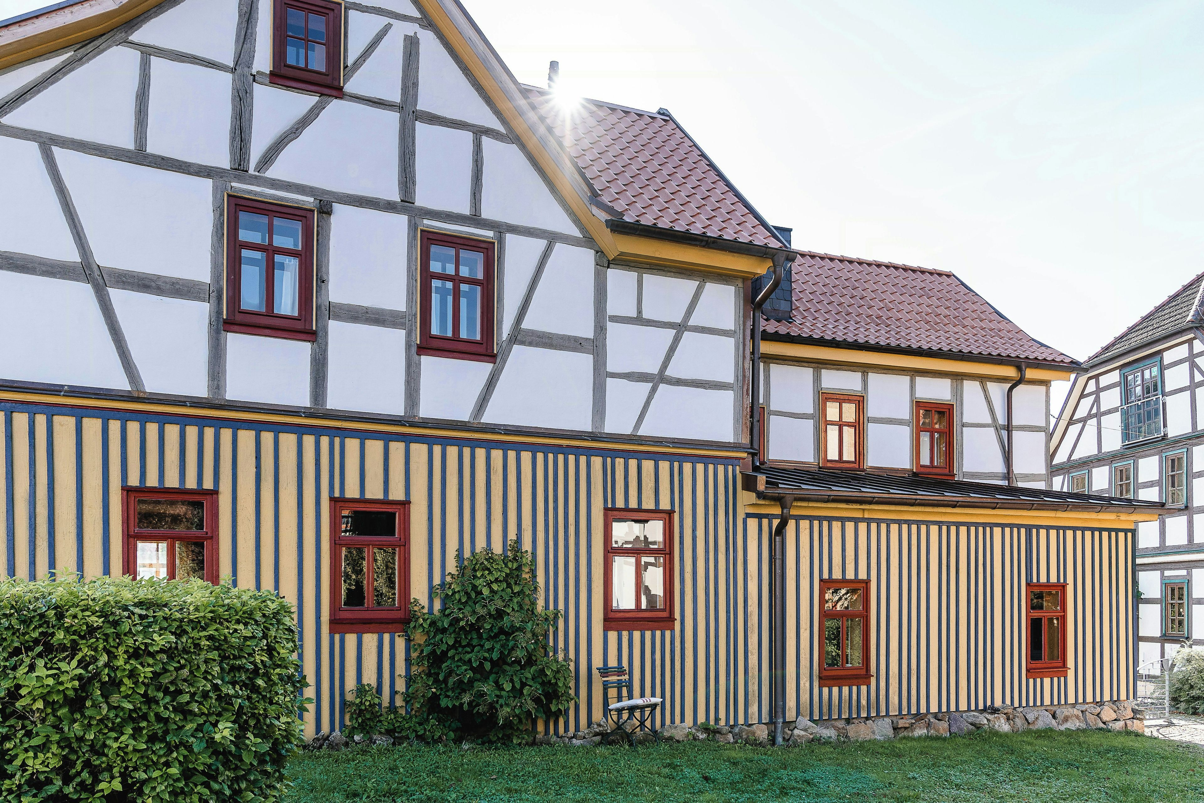 Ein traditionelles Fachwerkhäuschen mit zahlreichen Fenstern und einem geneigten Dach.