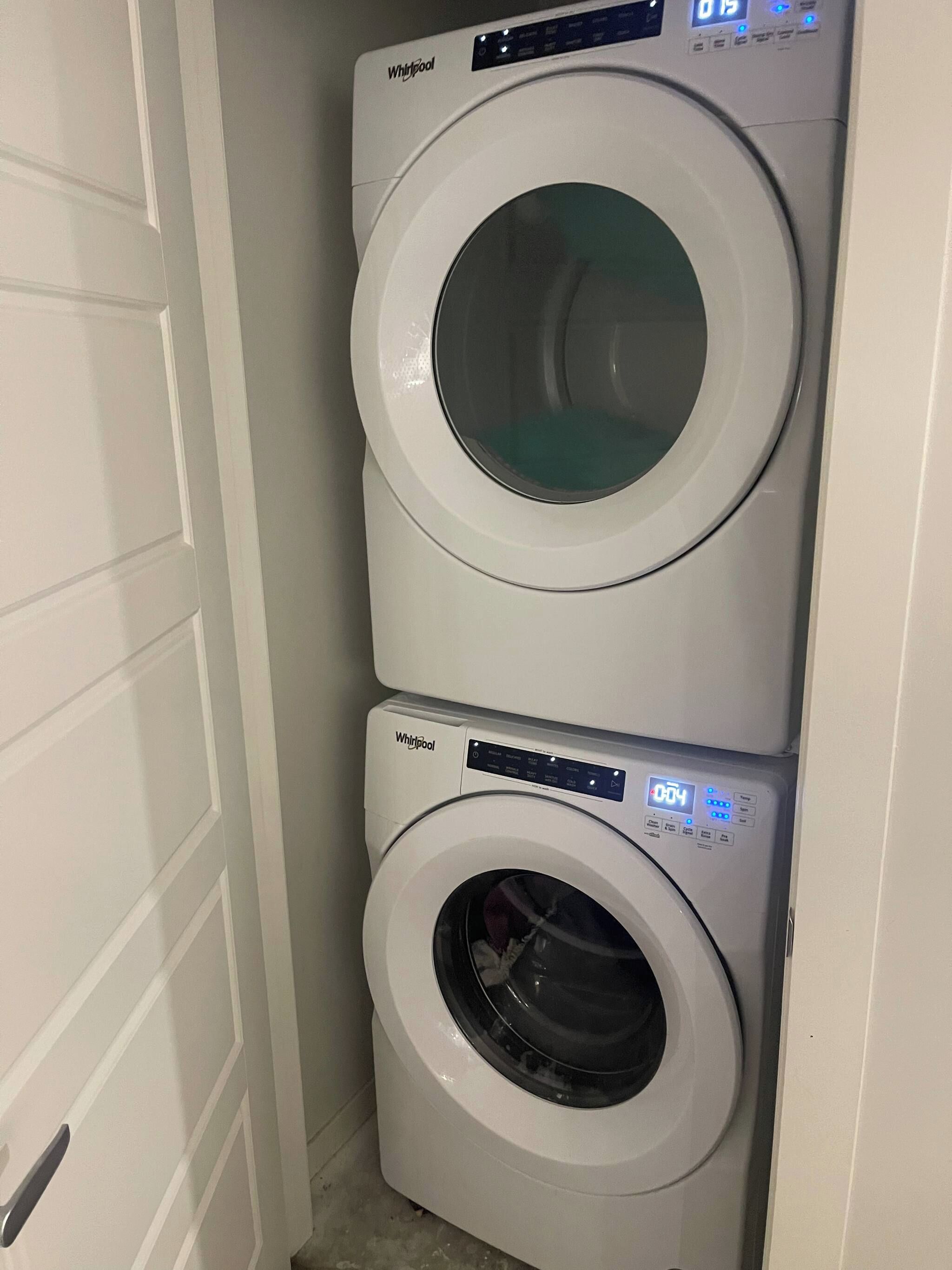 Una lavadora y secadora apiladas en un cuarto de lavado.