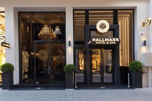 A modern hotel entrance with a glass facade, a prominent sign, and a decorative chandelier. - Manning Residence (Istanbul)
