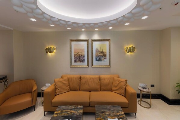 A modern living room with a sofa, two side chairs, a coffee table, and framed artwork on the wall. - Manning Residence (Istanbul)