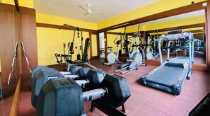A gym with various exercise equipment including dumbbells, a treadmill, and weight machines. - Sea Esta Colva (colva)