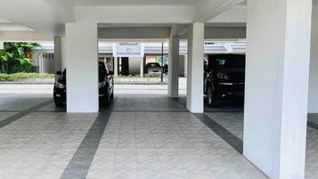 Un estacionamiento techado con varios coches aparcados bajo una estructura.