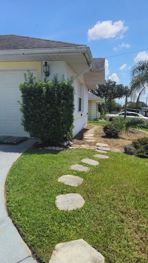 A residential property with a paved driveway, a stone pathway, and a well-maintained lawn. - Private Deltona Studio | Travel Nurse Friendly (Deltona)