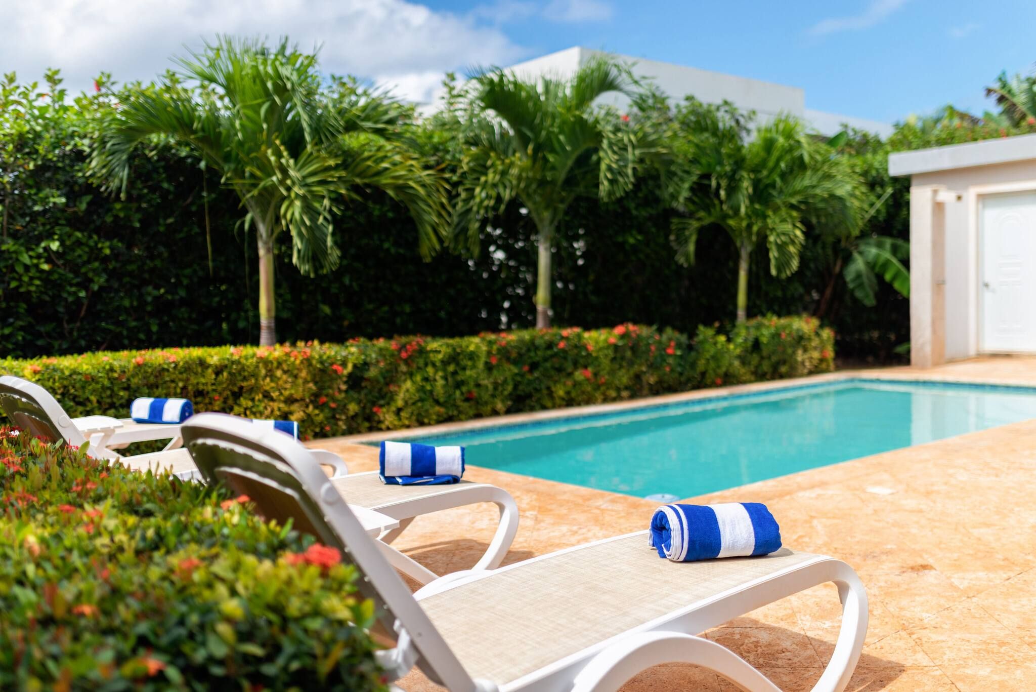 A poolside area with lounge chairs and a pool.