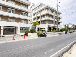 A multi-story residential building with balconies, a gated entrance, and a street in front. - Luxury Gateway 2BR Bayahibe Pool Beach (Bayahíbe La Romana)